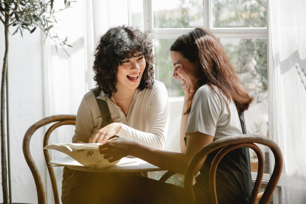Two friends looking over paperwork related to pregnancy
