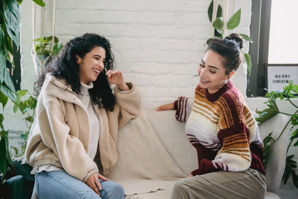 A woman telling her friend she's pregnant